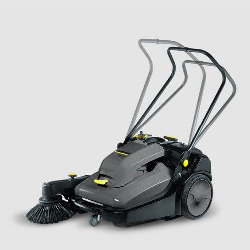 Industrial floor sweeper with brushes and handles for cleaning large areas.