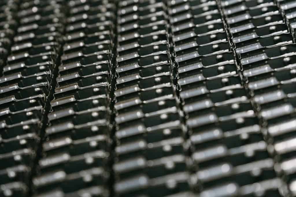 Close-up of black metal manufacturing components in a factory setting.