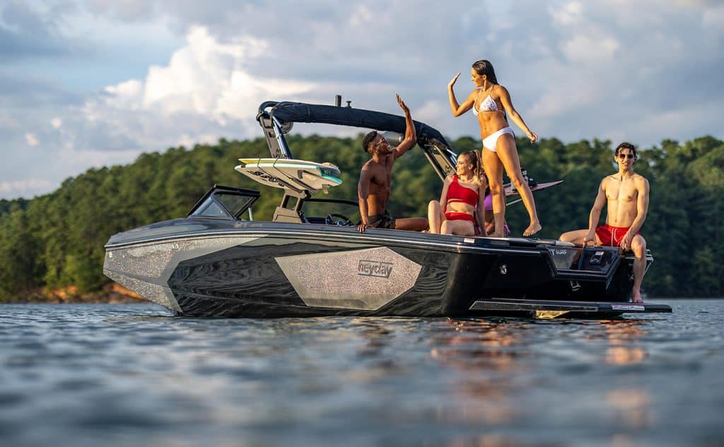 Boat with people relaxing and having fun on the water during sunny weather.