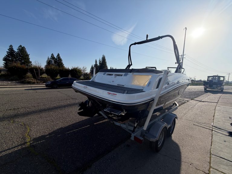 Bayliner VR5 boat on trailer ready for transport in bright sunlight.