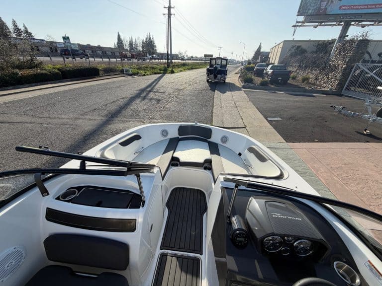View of a boat dashboard and front deck in an outdoor setting.