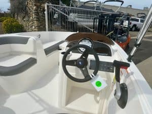 Boat dashboard with steering wheel, gauges, and control levers for optimal navigation.