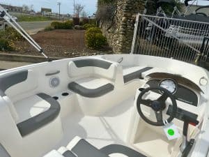 Close-up of a sleek boat interior featuring cushioned seats and a steering wheel for navigation.