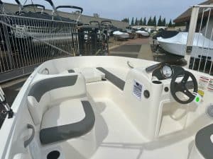 Recreational boat interior featuring steering wheel, seating, and dashboard for optimal boating expe.
