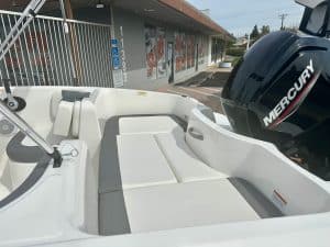 Aluminum boat with cushioned seating and Mercury outboard motor for fishing and leisure.