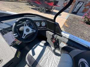 Close-up of boat cockpit with steering wheel and controls.