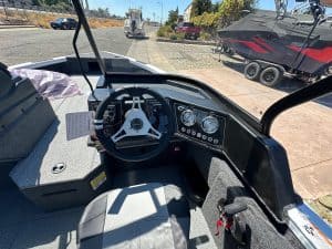 Close-up of boat's dashboard, steering wheel, and control panel.