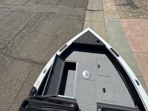 Close-up of boat interior with storage compartments and deck.
