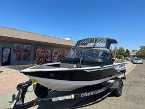 Black and white Crestliner Fish Hawk boat on trailer outside dealership.