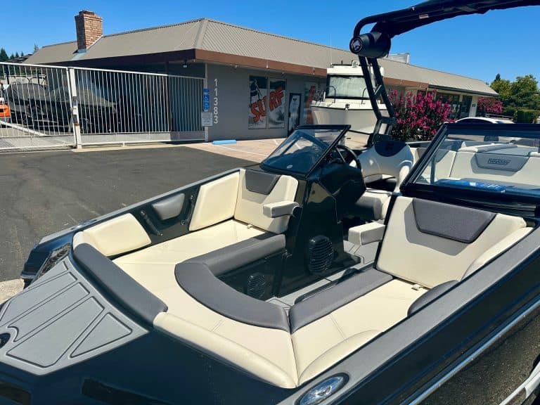 Modern boat with spacious seating and wakeboard tower for water sports.