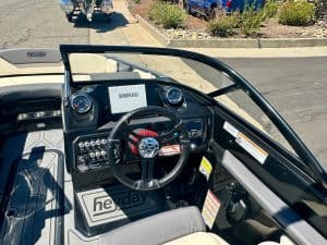 Close-up of the Heyday WT2 DC boat dashboard with steering wheel and controls.