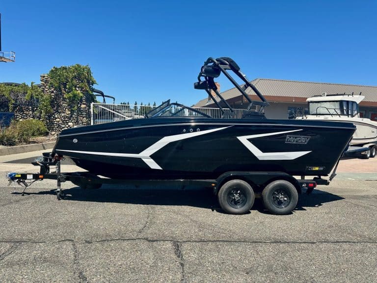 Black and white boat on trailer for sale at dealership.