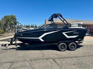 Boat on trailer for sale with sleek black and white design.