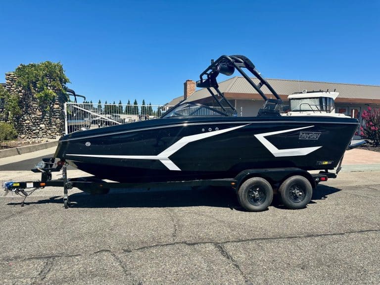 Boat on trailer for sale with sleek black and white design.