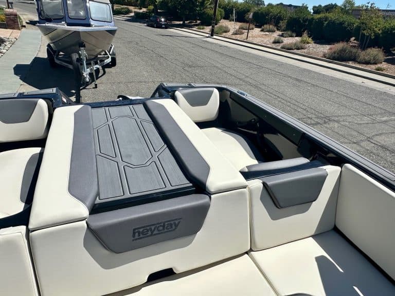 Luxury boat interior with white and black seating and sun pad.