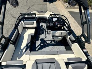 Close-up of boat cockpit with steering wheel and control panel.