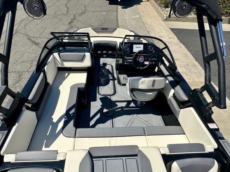 Close-up of boat cockpit with steering wheel and control panel.