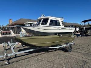 Boat with trailer at dealership lot for sale.