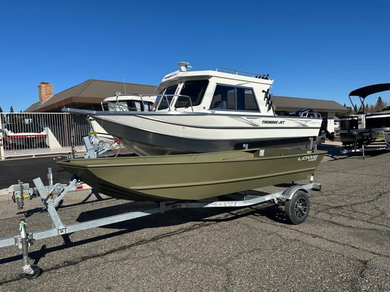 Boat with trailer at dealership lot for sale.