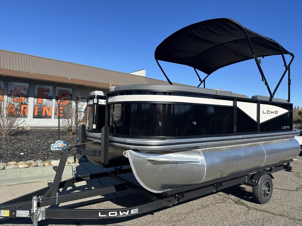 Pontoon boat on trailer with canopy, ideal for family boating and water recreation.