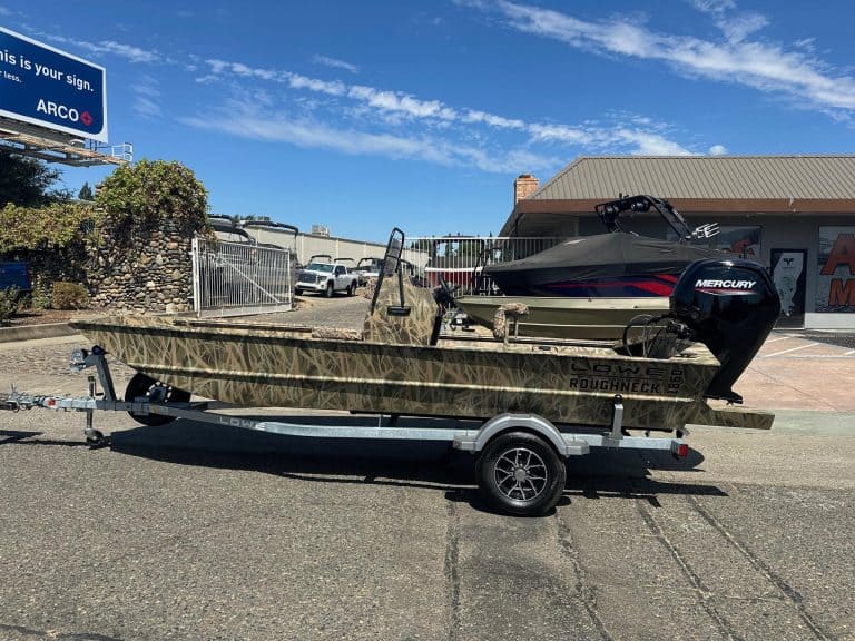 Boat with Mercury 80HP jet engine on trailer at dealership lot.
