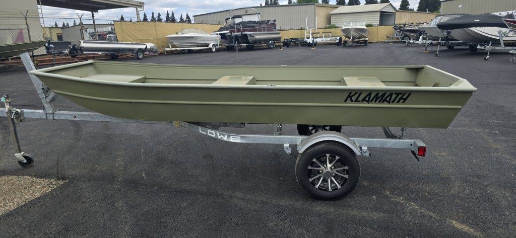 Klamath 10 JAC boat on trailer at dealership lot.