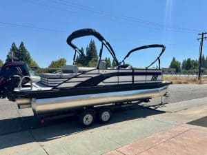 Pontoon boat on trailer with Mercury 200HP Pro Xs engine.
