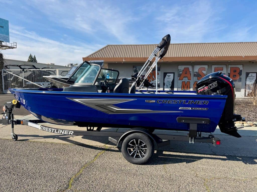 Blue Crestliner Kodiak boat with Mercury 115HP engine on trailer.