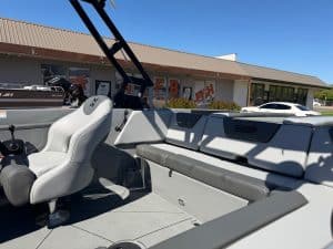 Modern surf boat with seating and wakeboard tower for water sports.