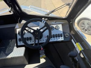 Close-up of Thunder Jet boat control panel with steering wheel and gauges.