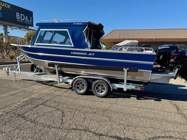 Boat on trailer with outboard motor, blue and white color.