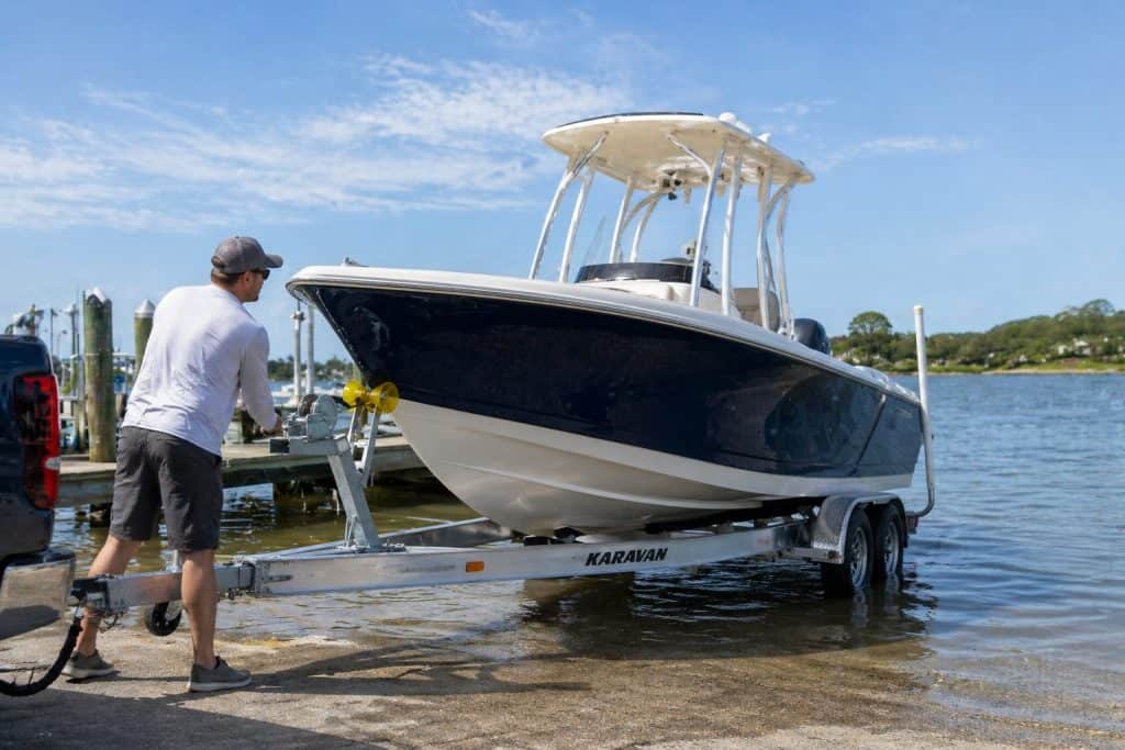 Boat trailer with boat on water, ready for launch or retrieval.