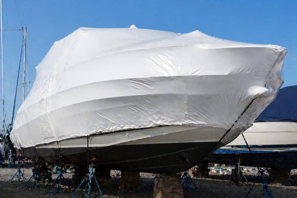 Boat covered with protective tarp during off-season maintenance.