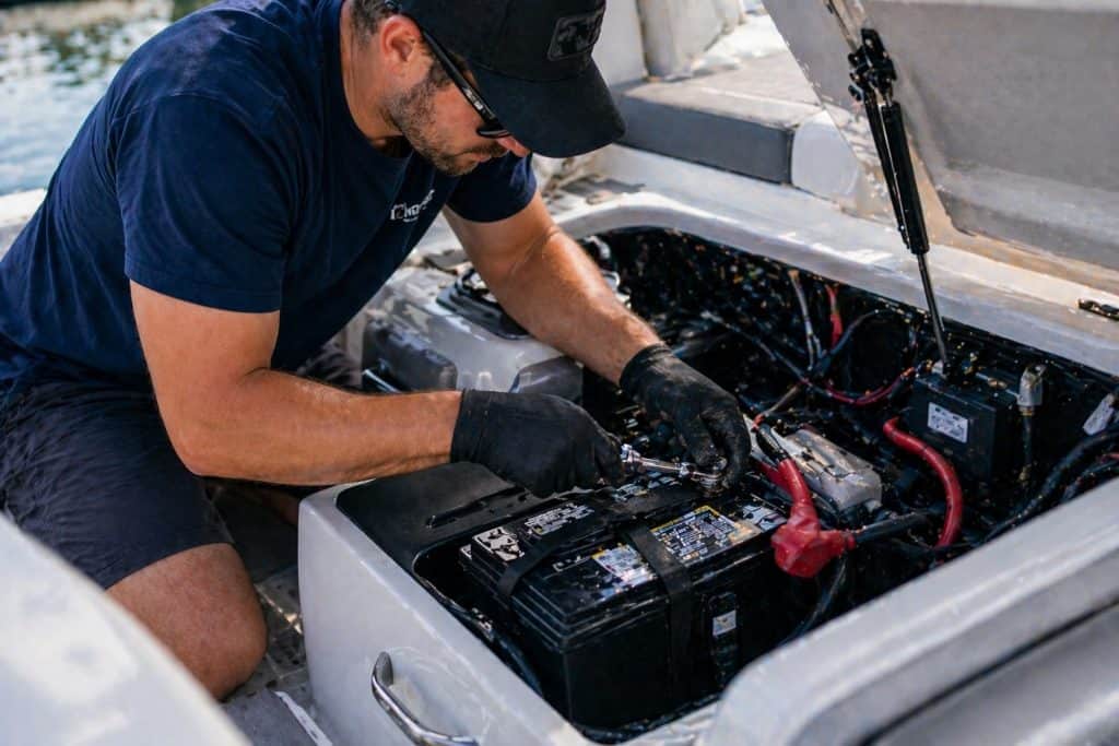 Technician replacing a car battery during maintenance or repair.