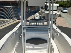 Close-up of a white boat with a steering console at a marina.