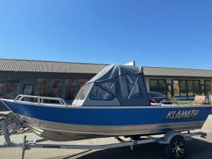Klamath 19 GTX boat with canopy on trailer, ideal for fishing and water sports.