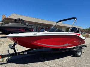 Red and white Bayliner M17 boat with Mercury 90HP engine on trailer.