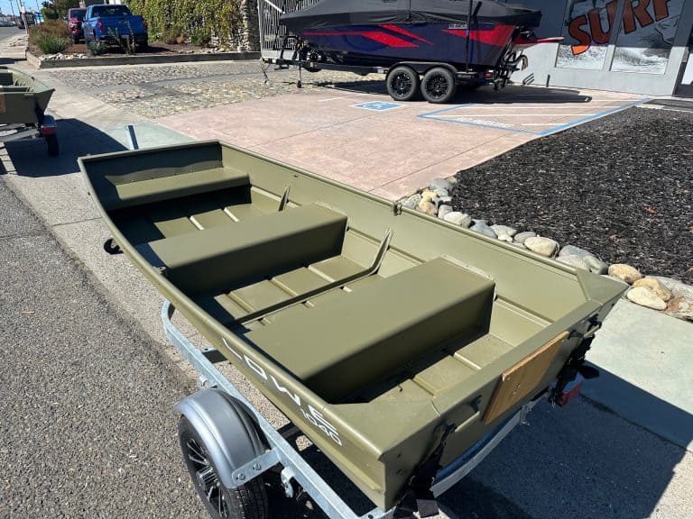 Small green fishing boat on trailer for outdoor water adventures.
