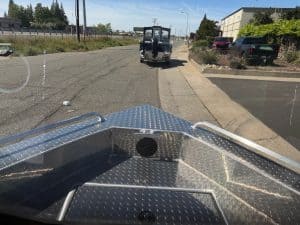 Aluminum boat with diamond plate surface and front-mounted trolling motor.