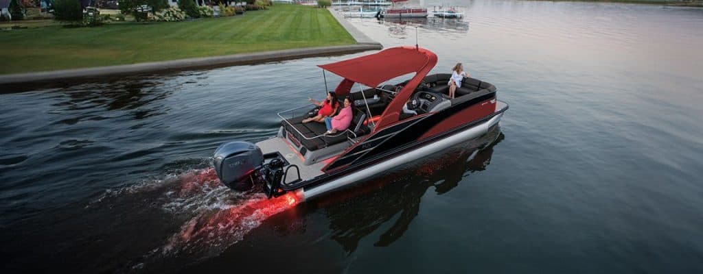 Luxury motorboat cruising on calm water during sunset, with passengers enjoying a scenic ride.