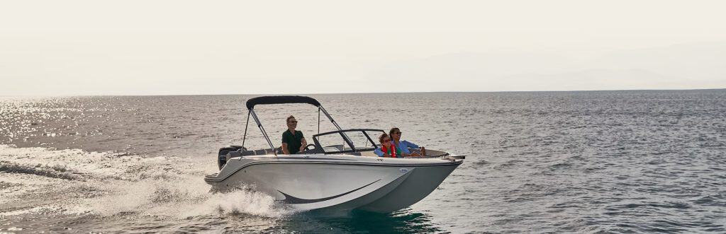 Boat cruising on open water with two passengers enjoying the ride.