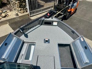 Aluminum boat deck featuring built-in storage compartments and tackle boxes for fishing gear.