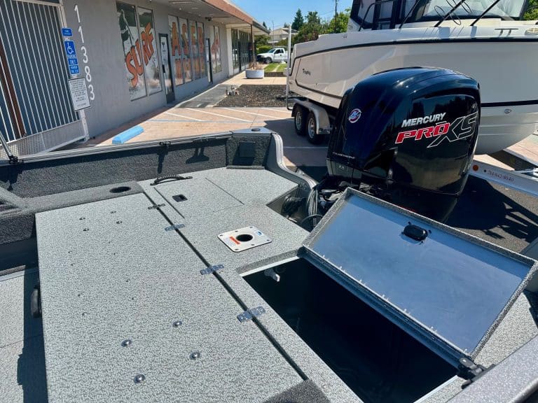 Boat with Mercury Pro XS outboard motor parked outside a marine store.