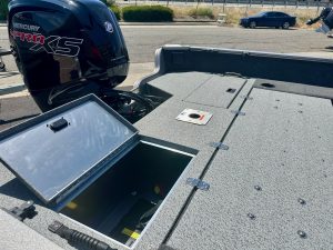 Outboard motor Mercury Pro XS on boat deck with storage hatch open.