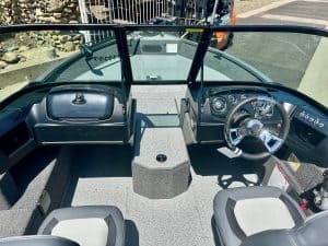 Marine boat dashboard with steering wheel and control panel.