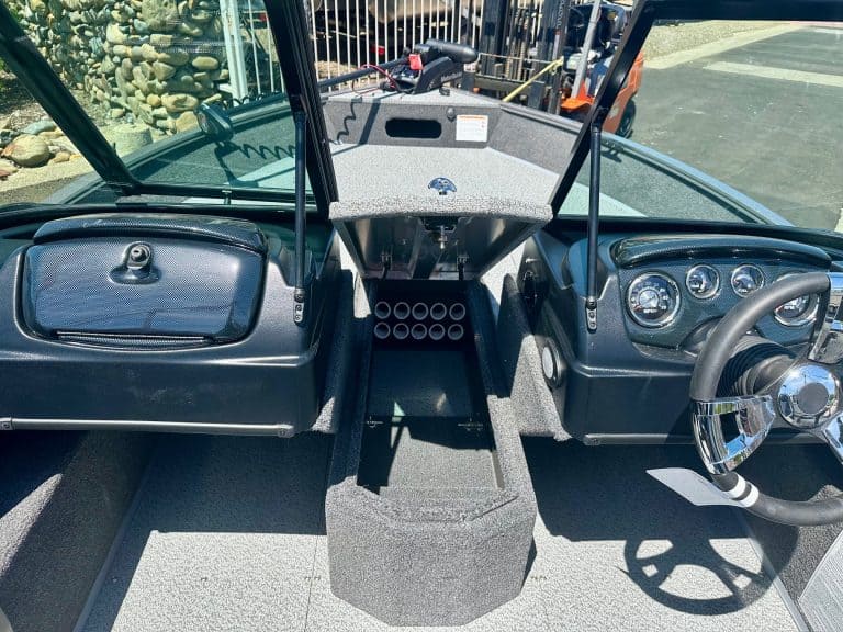 Boat dashboard with steering wheel, gauges, and control panel for marine navigation.