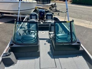 Boat with dual windshields and seating for fishing or leisure activities.