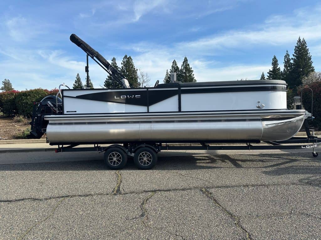 Luxury Lowe pontoon boat with a trailer, ideal for recreational boating and water adventures. Perfec.