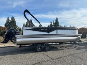 Pontoon boat with outboard motor on trailer for sale at ASFB Marine.