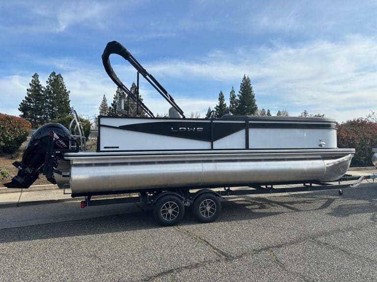 Pontoon boat with outboard motor on trailer for sale at ASFB Marine.
